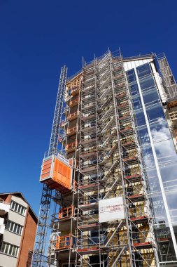 Lulea, İsveç - 20 Haziran 2018: Düşük melek görünümünü Kungsgatan Street iskele ile yüksek yükselen bina inşaatı ve ve geçici Asansör bağlı bina.