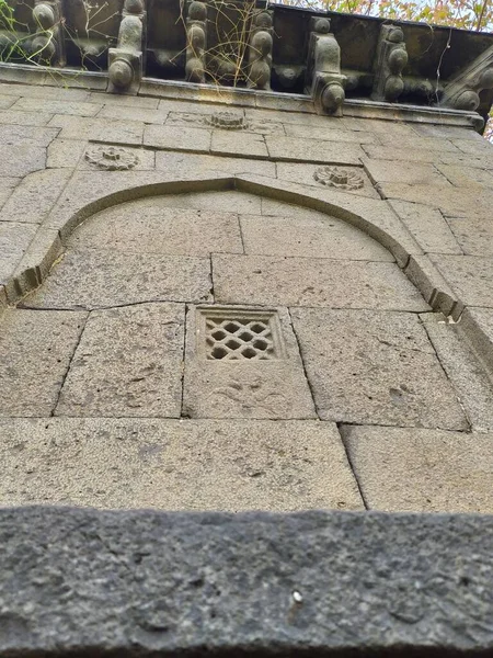 Tarihsel anıttan yapılmış taş tuğlalardan oluşan pencere duvarına oyulmuş tasarım.