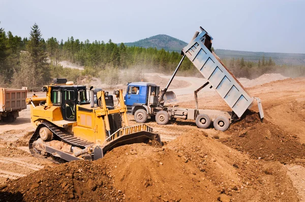 Vrachtwagens Aan Boord Lossen Zand Een Ravijn Waarna Bulldozers Rest — Stockfoto