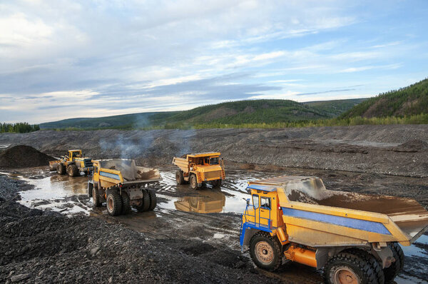 Wheel loader loads mountain soil into the back, Mining trucks transport mountain soil for further processing