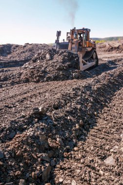 Dağlık bir orman bölgesinde doğal altın madenciliği. Buldozerler, güneşli bir yaz gününde bir dağ ormanında çalışma sürecinde.
