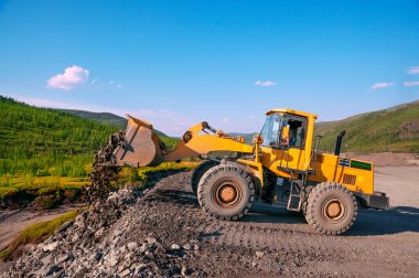 Tekerlek Yükleyici İnşaat Alanının dışındaki Taş Taşları Boşaltıyor