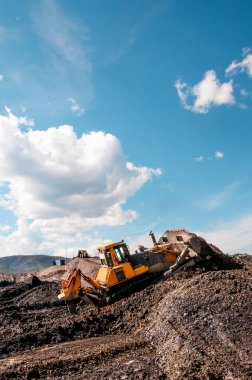Dağlık alanlarda doğal altın madenciliği yapan Buldozer, doğal altın yoğunluğunun arttığı dağ toprağını toplar. Sonra, tekerlek yükleyiciler bu dağ toprağını yıkamak için özel endüstriyel ekipmanlara taşıyorlar.