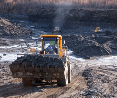 Dağlık alanlarda doğal altın madenciliği yapan Buldozer, doğal altın yoğunluğunun arttığı dağ toprağını toplar. Sonra, tekerlek yükleyiciler bu dağ toprağını yıkamak için özel endüstriyel ekipmanlara taşıyorlar.