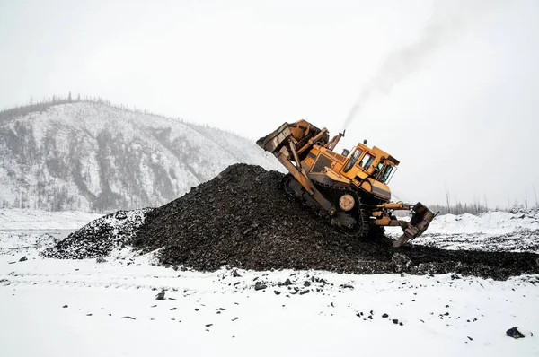 Endüstriyel bir bölgedeki dağlık bir bölgede buldozer dağ toprağı kazıyor. Madencilik.