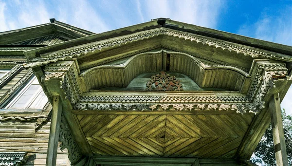 Canopy over main entrance of old wooden house from times of Russian Empire There are carved decorations on facade decor. Architecture of European part of Russia . For various reasons, these old houses are getting smaller and smaller every year.