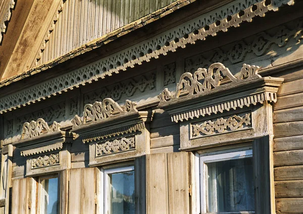 stock image Fragment of window of old Russian wooden house from times of Russian Empire. There are carved decorations on facade decor. Architecture of European part of Russia . For various reasons, these old houses are getting smaller and smaller every year.