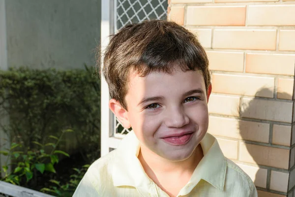 ブラジル人の7歳の子供は笑顔で 顔の一部は太陽の光に照らされています — ストック写真