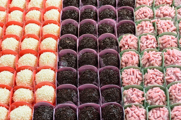 Various types of brigadiers organized in rows. Chocolate, red fruit and white chocolate brigadiers.