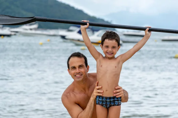 Padre Sosteniendo Cintura Del Hijo Con Tabla Surf Mano — Foto de Stock