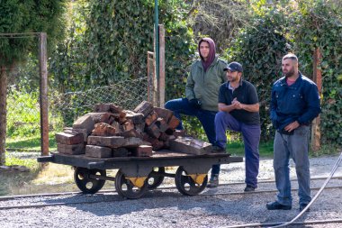 Campos do Jordao, Sao Paulo / Brazil, Temmuz 2019: Buharlı lokomotifi odunla doldurmayı bekleyen işçiler.