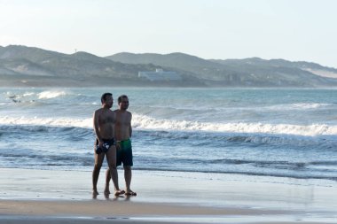 Natal, Ponta Negra Sahili, Rio Grande do Norte, Brezilya, 27 Temmuz 2019: Ponta Negra plajında yürüyen ve konuşan eşcinsel çift.