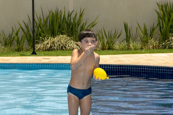 Letni Chłopiec Ręką Ustach Trzymając Bombę Wodną — Zdjęcie stockowe