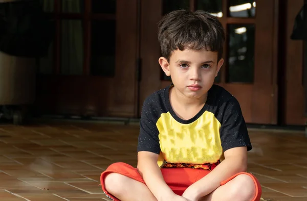Шестилетний Мальчик Сидит Серьезным Выражением Лица Черно Желтой Рубашке — стоковое фото
