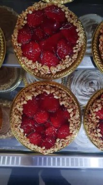 Kremalı küçük çilekli turtalar ve doğranmış çilekler ve kaju fıstıkları _ dikey.