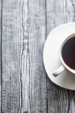 Beyaz fincanda kahve, gri ahşap arka planda beyaz bir fincan.