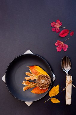 Sonbahar yapraklarında siyah tabak ve çatal bıçak.. 