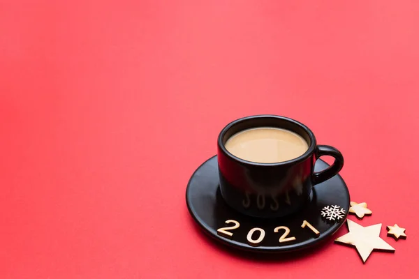 2021 numaralı Noel kompozisyonu ve kırmızı arka planda bir fincan kahve. Yeni yıl 2021 ve Noel konsepti