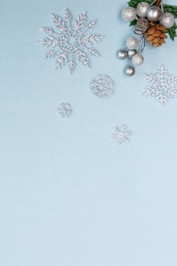 Gümüş kar taneleri, boncuklar ve dikenlerle Noel mavisi arka plan