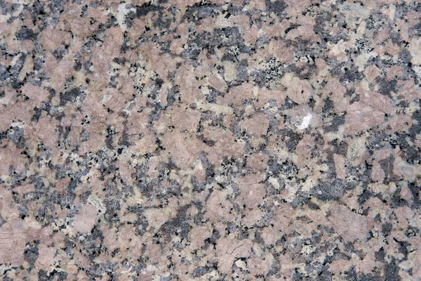 Close-up granite slab, light pink interspersed with gray and black.