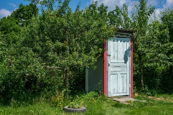 A rustic toilet stands outside among garden trees and green grass. — Stock Image Rustic Toilet Stands Garden Trees Green Grass Royalty Free Stock Images