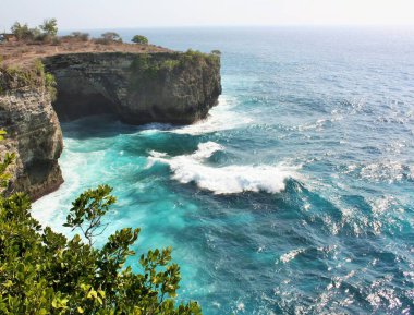 Endonezya, Nusa Penida 'daki Melek' in Billabong 'u yakınlarındaki kayalıkların ve mavi okyanus suyunun manzarası.
