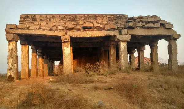 Günbatımında eski bir tapınağın kalıntıları Hampi, Karnataka, Hindistan 'daki Hemakuta tepesinde yer alıyor.