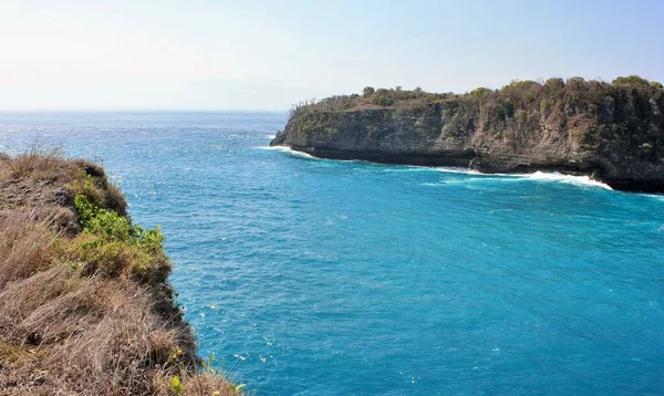 Endonezya, Nusa Penida 'daki Melek' in Billabong 'u yakınlarındaki kayalıkların ve mavi okyanus suyunun manzarası.