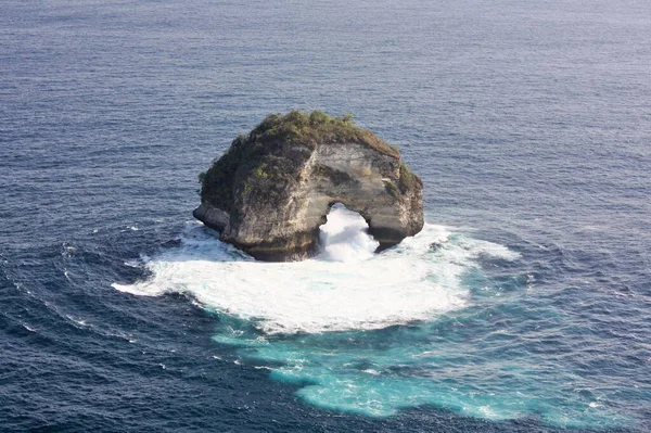 Endonezya 'daki Nusa Penida Adası' ndaki Banah Cliff 'ten alınan mavi okyanusla çevrili doğal kemer.