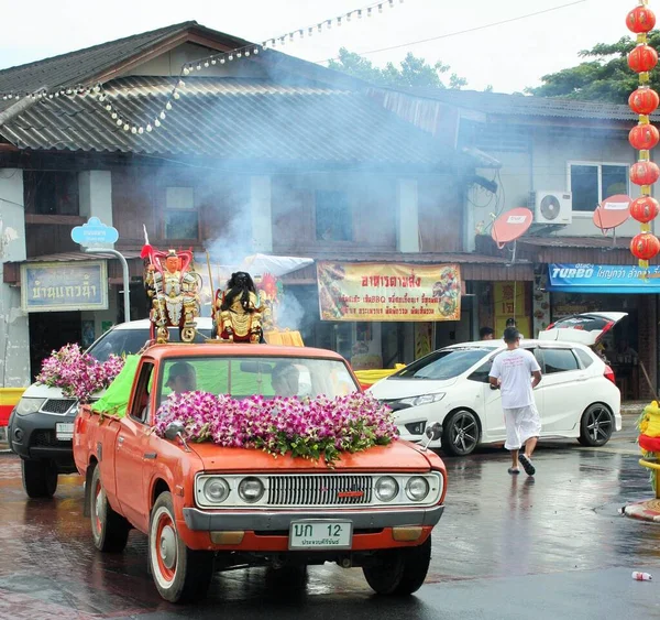 Phuket Town / Tayland - 7 Ekim 2019: Phuket Vejetaryen Festivali veya Dokuz İmparator Tanrısı Festivali sokak geçidi, eski bir turuncu Datsun kamyonetinin arkasında Çin Taoist heykelleriyle geçit töreni