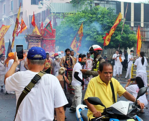 Phuket Town / Tayland - 7 Ekim 2019: Phuket Vejetaryen Festivali veya Dokuz İmparator Tanrısı Festivali geçit töreninde insanlar fotoğraf çekiyor, motosikletli adam, bir polis memuru ve Taocu fanatikler