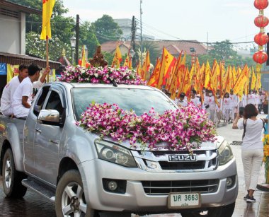 Phuket Town / Tayland - 7 Ekim 2019: Phuket Vejetaryen Festivali veya Dokuz İmparator Tanrısı Festivali sokak geçidi, çiçeklerle kaplı kamyonet ve pankart taşıyan bir grup insan