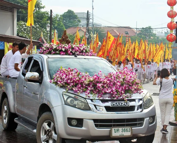Phuket Town / Tayland - 7 Ekim 2019: Phuket Vejetaryen Festivali veya Dokuz İmparator Tanrısı Festivali sokak geçidi, çiçeklerle kaplı kamyonet ve pankart taşıyan bir grup insan