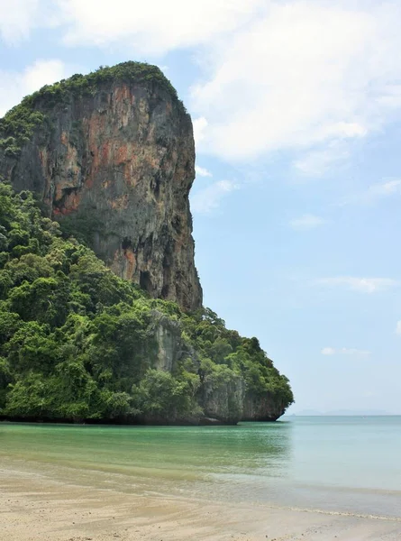 Tayland 'ın Krabi Eyaleti' ndeki Railay West Beach 'te suyun üzerinde dik kireçtaşı kayalıklar yükseliyor.