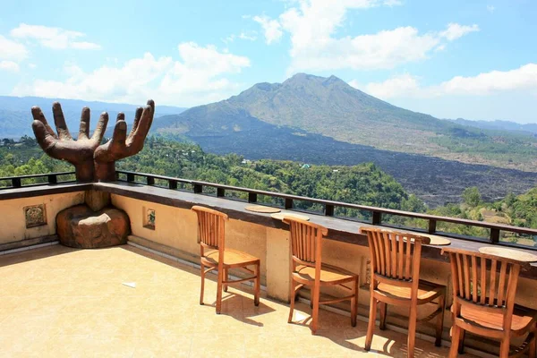 Kintamani, Bali / Endonezya - 3 Eylül 2019: Terastan Batur Dağı 'nın manzarası geniş bir heykel ve ahşap sandalyelerle dolu