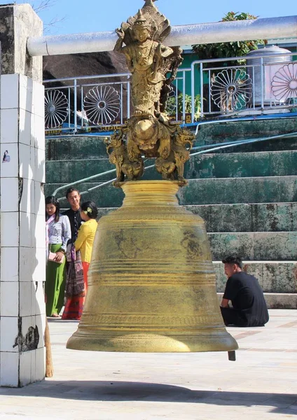 Kyaiktiyo Pagoda (Altın Kaya) yakınlarındaki süslü Buda heykeli tarafından askıya alınmış büyük bir çan.