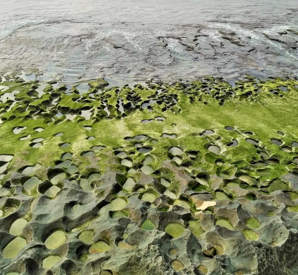 Bali, Endonezya 'da aşınmış kaya ve yeşil yosunlu Balangan Sahili