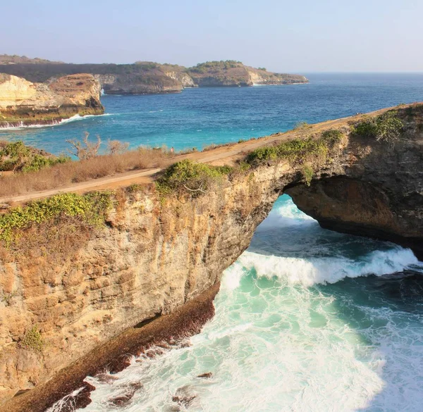 Endonezya 'da, Nusa Penida, Broken Beach' te doğal bir kemerin altında dalgalar akıyor.