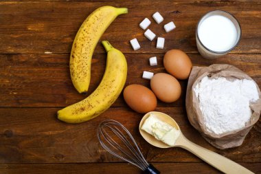 ahşap bir arka plan üzerinde muz pasta yapmak için malzemeler