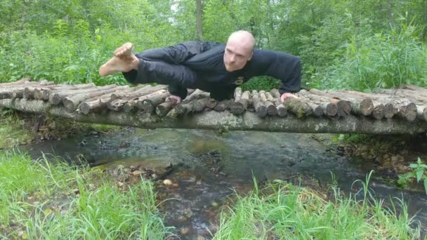 Master Tai Chi Performs Morning Exercise Wooden Bridge Stream — Stock Video