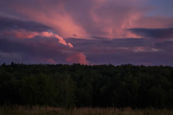 Zachód słońca z dramatycznymi chmurami fuksji. — Zdjęcie stockowe