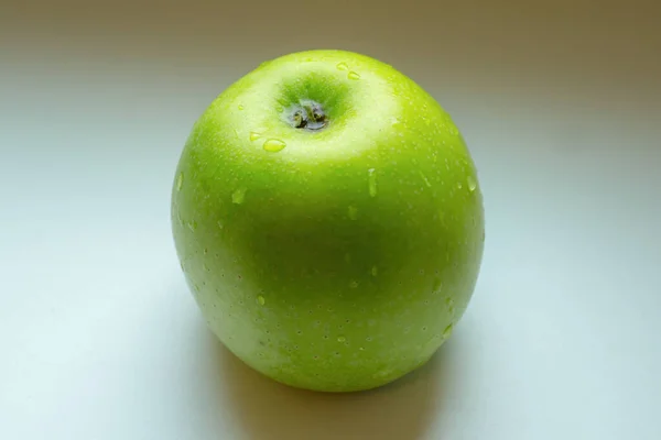 Mokre zielone jabłko na białym tle z cieniami. — Zdjęcie stockowe