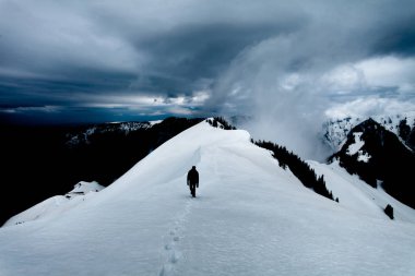Kar, arkasından yaklaşan bir fırtına yürürken uzun yürüyüşe çıkan kimse