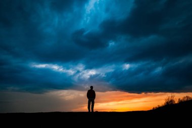 Adam siluet duran dramatik bulutlar arka plan