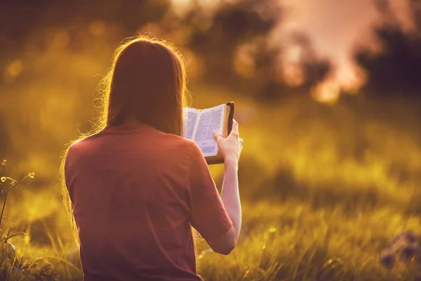 Gün batımında İncil okuma kız