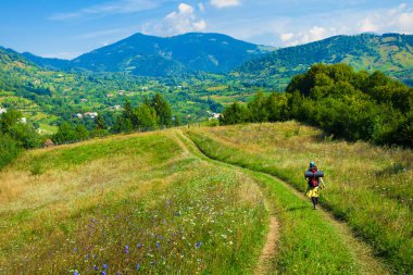 Transilvanya tepelerde sarma yol üzerinde yürüyen turist