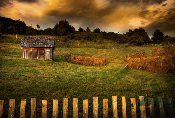 Eski ahır ve gün batımında haystacks
