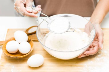 Masanın üzerinde yumurta, tuz, un ve hamur var. Ekmeğin hazırlanması