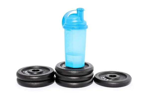 Protein shaker on a pedestal of weight plates — Stock Photo, Image
