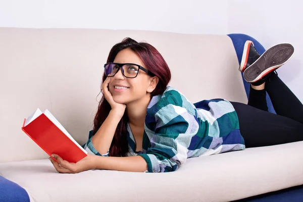 Chica joven fantaseando mientras lee un libro — Foto de Stock